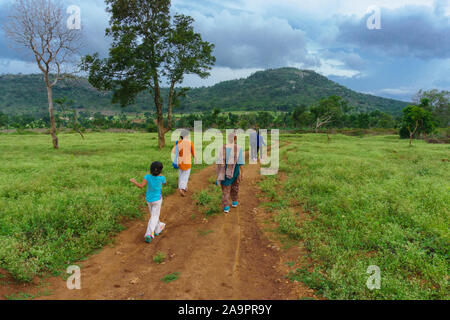 Eine Gruppe von Reisenden entlang eine Trail fahren durch eine Wiese - fotografiert am Dorfrand von bandipur National Park (Karnataka, Indien) Stockfoto