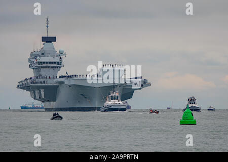 Die Royal Navy Flugzeugträger HMS Prince of Wales (R09) feierte sein Debüt in Portsmouth, Großbritannien am 16. November 2019, begrüßt von Tausenden von Mitgliedern der Öffentlichkeit an der Küste und am Eingang zum Hafen. Stockfoto