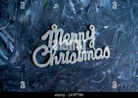 Frohe Weihnachten Text auf grauem Hintergrund. Silber glänzend Frohe Weihnachten Handschrift. Urlaub Konzept Stockfoto