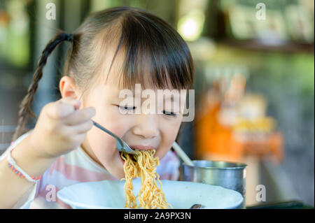 Asiatische kind Mädchen Essen Nudeln zu Hause Stockfoto