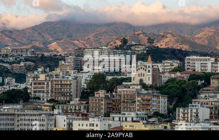 Sonnenaufgang in Messina Hafen mit Blick auf die Innenstadt und die Berge im Hintergrund, Italien Stockfoto