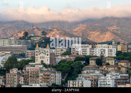 Sonnenaufgang in Messina Hafen mit Blick auf die Innenstadt und die Berge im Hintergrund, Italien Stockfoto