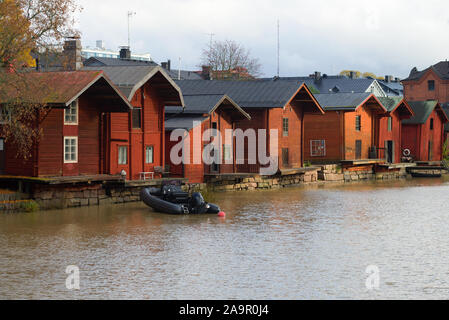 Alte rote Ställe am Ufer des Flusses Porvoonjoki an einem bewölkten Oktober Tag. Porvoo, Finnland Stockfoto