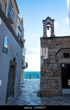 Am Abend Winter auf den Straßen von Polignano a Mare Altstadt, Provinz Bari, Apulien, Süditalien. Glockenturm der Kirche von Santo Stefano. Stockfoto