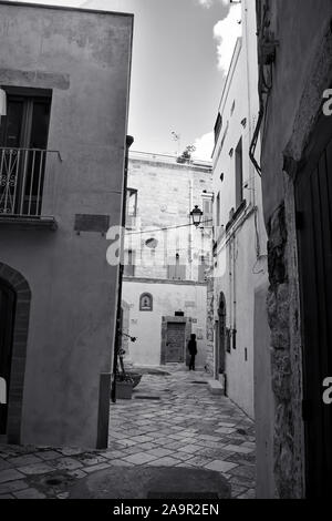 Am Abend Winter auf den Straßen von Polignano a Mare Altstadt, Provinz Bari, Apulien, Süditalien. Schwarz-weiß-Bild. Stockfoto