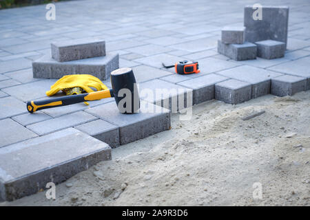 Pflastersteine Weg ebnet Hintergrund. Installation von Tools zur Vordergrund Stockfoto