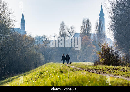 Straubing, Deutschland. 17. Nov, 2019. Wanderer werden auf einem donaudamm vor der Karmeliterkirche (l) und die Basilika von St. Jakob. Foto: Armin Weigel/dpa/Alamy leben Nachrichten Stockfoto