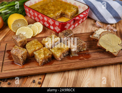 Gelee mit Fleisch, Rindfleisch Aspik, traditionelle russische Gericht, Portion auf einem Teller, Senf und Meerrettich Stockfoto