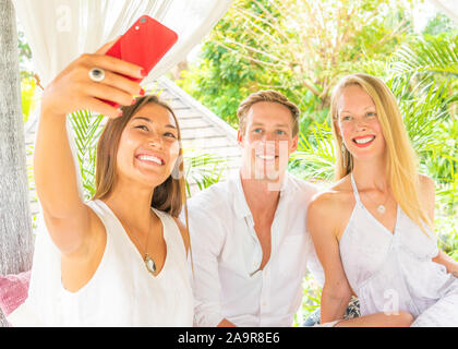 Junge fröhliche Freunde in allen Weiß, wobei selfie gekleidet Stockfoto