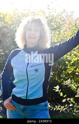 Reife Frau mittleren Alters trägt einen retro Adidas Trainingsanzug top in den 1970er Stockfoto
