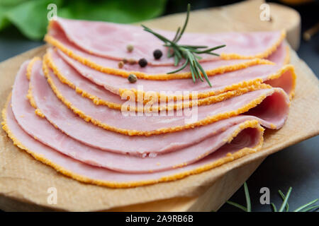 Close up frischer Hum Fleisch für Sandwiches, dunklen Kammer mit Gemüse für den Hintergrund. Stockfoto