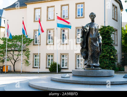 Die Stadt Luxemburg/Luxemburg - 10. August, 2019: Place Clairefontaine mit Fahnen von Luxemburg und die Statue der Großherzogin Charlotte von Luxembour Stockfoto