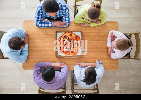 Menschen Hände greifen Pizza aus Lieferbox, Ansicht von oben Stockfoto