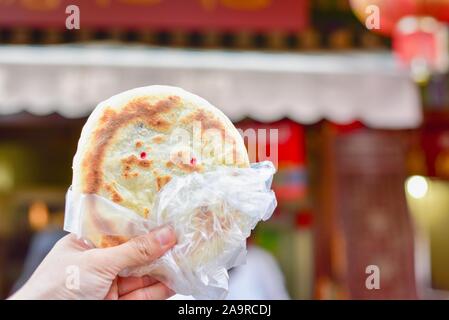 Hand, die traditionelle Guandu Pfannkuchen bei Guandu antike Stadt in Kunming Stockfoto