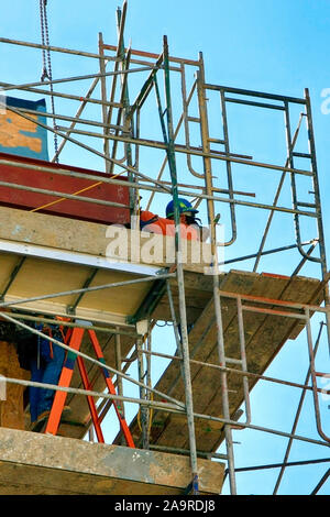 Zwei Bauarbeiter Tragen von Schutzausrüstung gehen über ihre Jobs, die hoch oben auf einem Gerüst in einem Projekt in Tucson AZ Stockfoto