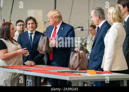 Präsident Donald J. Trumpf visits und spricht mit Arbeiter, wie er von Bernard Arnault, CEO von LVMH Moet Hennessy verbunden ist; Carlos Sousa der General Manager von Louis Vuitton Herstellung USA, und Berater des Präsidenten Ivanka Trump, während einer Tour Donnerstag, 17. Oktober 2019, in der Louis Vuitton Workshop - Rochambeau in Alvarado, Texas. Stockfoto