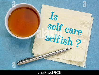 Ist Self Care egoistisch? Handschrift auf eine Serviette mit Kaffee. Körperpflege und Wellness Konzept. Stockfoto