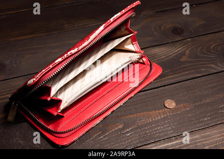 Alt, abgenutzt, leer, Buchse, rot, Geldbeutel und 1 Euro Cent auf eine leere Holz- Hintergrund. Der Begriff der Armut, Hunger Stockfoto
