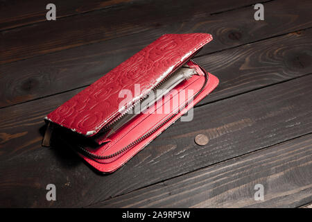 Alt, abgenutzt, leer, Buchse, rot, Geldbeutel und 1 Euro Cent auf eine leere Holz- Hintergrund. Der Begriff der Armut, Hunger Stockfoto