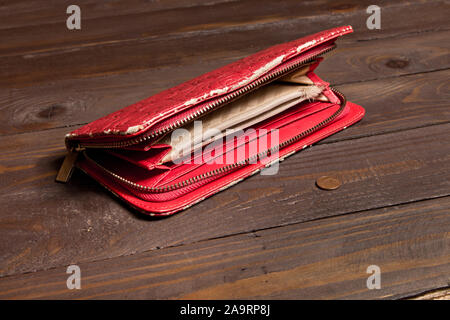 Alt, abgenutzt, leer, Buchse, rot, Geldbeutel und 1 Euro Cent auf eine leere Holz- Hintergrund. Der Begriff der Armut, Hunger Stockfoto