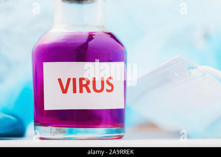 Flasche mit der Aufschrift Virus auf dem Tisch. Unerlaubte Herstellung von toxischen Substanzen Stockfoto