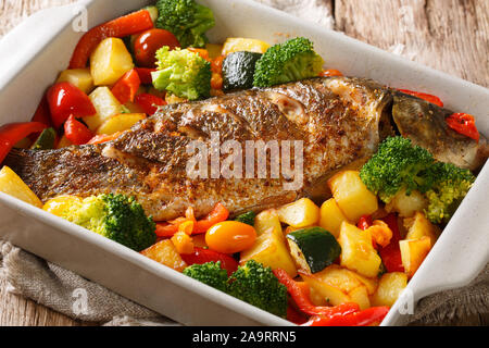 Gebackene Karpfen mit Kartoffeln, Zucchini, Brokkoli und Pfeffer close-up in einer Auflaufform auf den Tisch. Horizontale Stockfoto