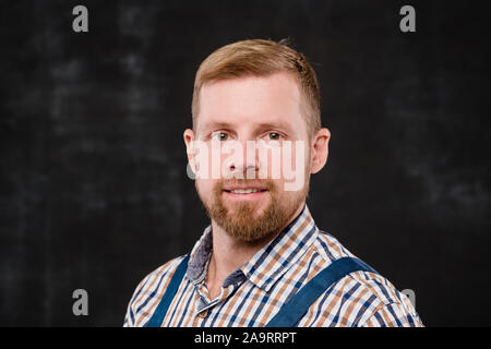 Junge Bartgeier Techniker in kariertem Hemd und blauen Overall an Sie Stockfoto