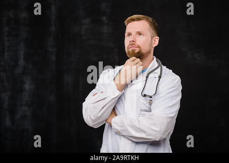 Junge Bartgeier Kliniker mit nachdenklichen Ausdruck steht in der Isolation Stockfoto