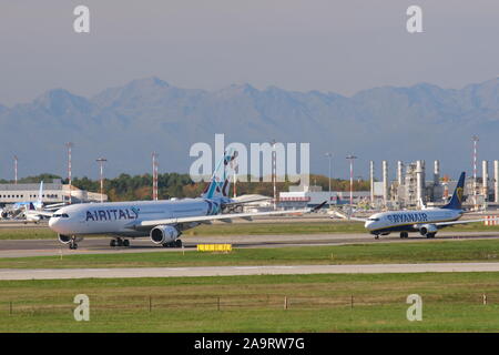 Mailand, Malpensa, Lombardei, Italien. Über 10/2019. Air Italy jet Flugzeug auf dem Flughafen Malpensa Landebahn. Im Hintergrund das Gebäude des Terminals Stockfoto