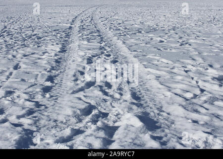 Spurweite und viele menschliche Fußspuren im Schnee Eis der gefrorenen Teich in solar Winter Wetter Stockfoto