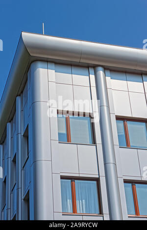 Hoher Teil der modernen neuen futuristischen Bürogebäude mit metallischen Farben dekoriert in hellem Sonnenlicht auf dem Hintergrund des blauen Himmels Stockfoto