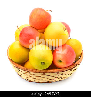 Rote und gelbe Äpfel in einem Weidenkorb auf weißem Hintergrund Stockfoto