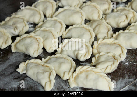 Knödel mit Kartoffeln auf der dunklen Küche. Knödel mit Kartoffeln (oder Hüttenkäse, Kohl, Kirschen, etc.) ist eine traditionelle ukrainische Dis Stockfoto