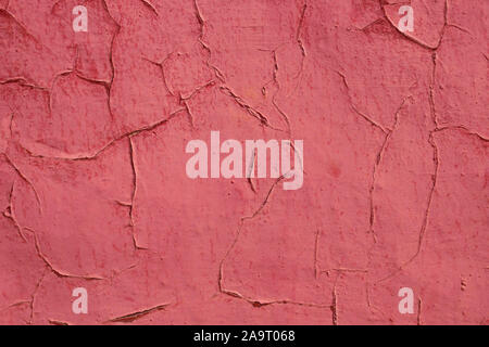 Alte beschossen und Gerissenes rot bemalten Wand im Sonnenlicht als Hintergrund Stockfoto