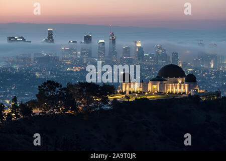 Los Angeles, Kalifornien, USA - 10. November 2019: Nebel Morgendämmerung der Griffith Park Observatorium. Mit Downtown Los Angeles Skyline in backgrou Stockfoto