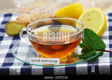 Guten Morgen Karte mit Tasse Tee, frische Minze, Zitrone und Ingwer Stockfoto