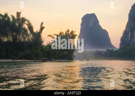 Glorreichen roten Sonnenuntergang am Li Fluss, Yangshuo, China, mit karst Berge und den Fluss Nebel Stockfoto