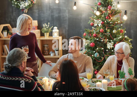 Mitglieder der großen Familie auf der Suche nach Reife blonde Frau mit einem Glas Wein Stockfoto