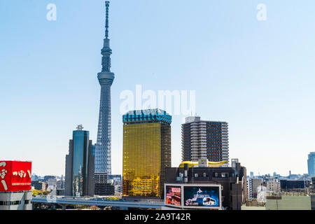 Ferner Schuß des Skytree Turm von Asakusa in Tokio gesehen mit der Asahi Bier taxizentralen und Sumida Ward Office im Vordergrund. Blue Sky. Stockfoto