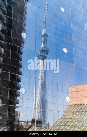 Die Tokyo Skytree gesehen in der reflektierenden schwarzen Gras Fassade der Asahi Brauerei Gebäude. Glasscheiben geben zerlegt die skytree. Stockfoto