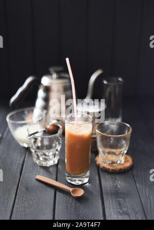 Eiskaffee mit Kokosmilch in hohes Glas vietnamesischen Stil auf schwarzem Hintergrund Kopie Raum Stockfoto