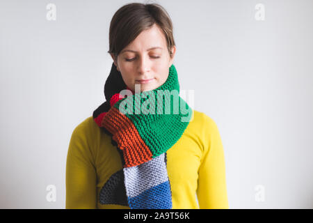 Hübsche junge Frau trägt einen Schal stricken Stockfoto