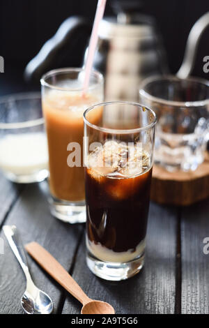 Erfrischendes Getränk. Eiskaffee mit Kondensmilch in hohe Gläser auf dunklem Hintergrund selektiven Fokus Stockfoto