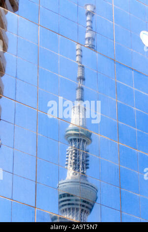 Die Tokyo Skytree gesehen in der reflektierenden schwarzen Gras Fassade der Asahi Brauerei Gebäude. Glasscheiben geben zerlegt die skytree. Stockfoto