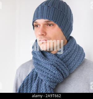 Cool mann im winter Mode. Das Tragen von Schal und Mütze stricken Stockfoto