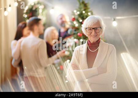 Happy Grandma, die Arme auf der Brust gekreuzt wünschen Ihnen frohe Weihnachten Stockfoto