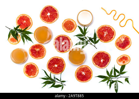 Grapefruitsaft mit Marihuana mit fruchtschnitten auf Weiß flach Stockfoto