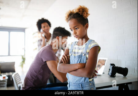 Frustriert trauriges Kind auf der Suche nach Aufmerksamkeit von voll berufstätigen Eltern Stockfoto