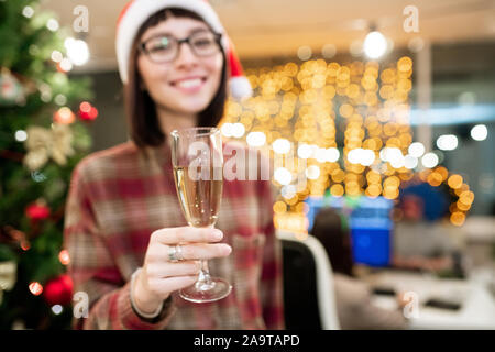 Hand der weiblichen Office Manager holding Glas Champagner vor der Kamera Stockfoto
