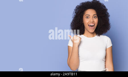 Aufgeregt überrascht African American Girl Zeigefinger Speicherplatz zu kopieren. Stockfoto